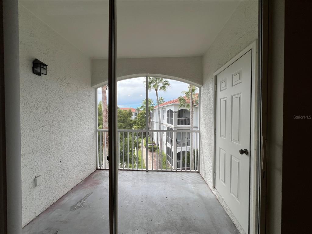 A covered balcony features a concrete floor, white walls, a screen enclosure, and a door — 2537 MAITLAND CROSSING WAY UNIT 308, ORLANDO, FL