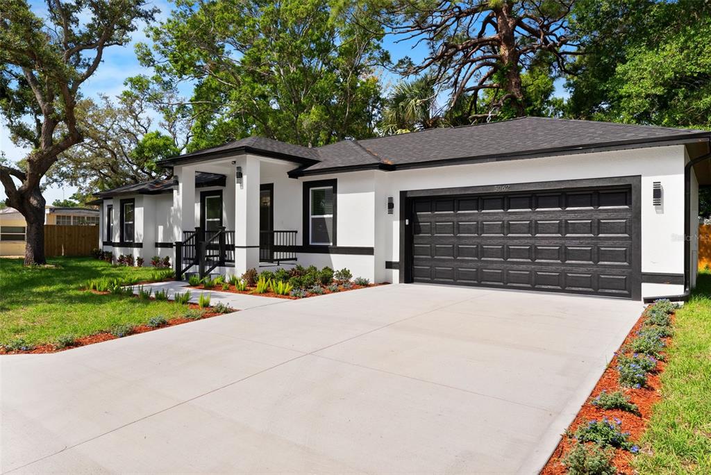 A single-story house with white stucco walls, black trim, and a two-car garage — 5062 80TH LANE N, ST PETERSBURG, FL