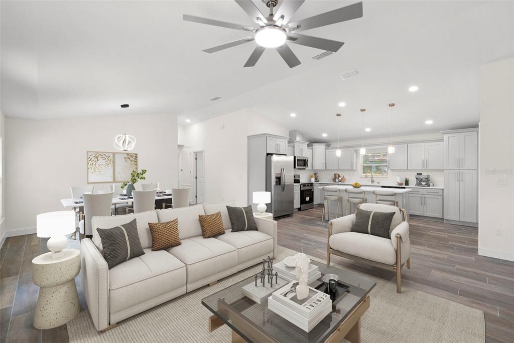 An open-concept living room and kitchen featuring light gray cabinetry and wood-look tile flooring — 5062 80TH LANE N, ST PETERSBURG, FL