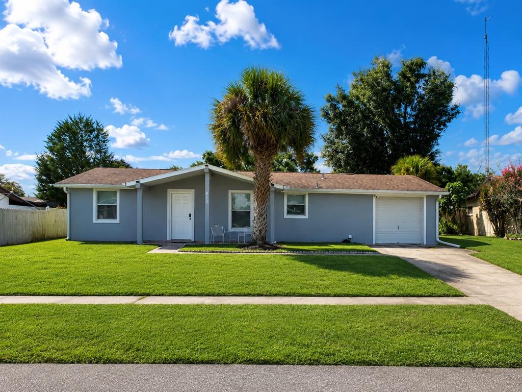A single-story gray house with a palm tree in the front yard and a garage — 14490 SW 41ST AVENUE ROAD, OCALA, FL