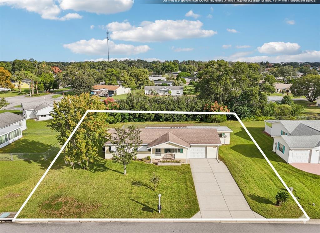 An aerial view shows a single-story house with a white garage and a large lawn — 10339 SE 179TH STREET, SUMMERFIELD, FL