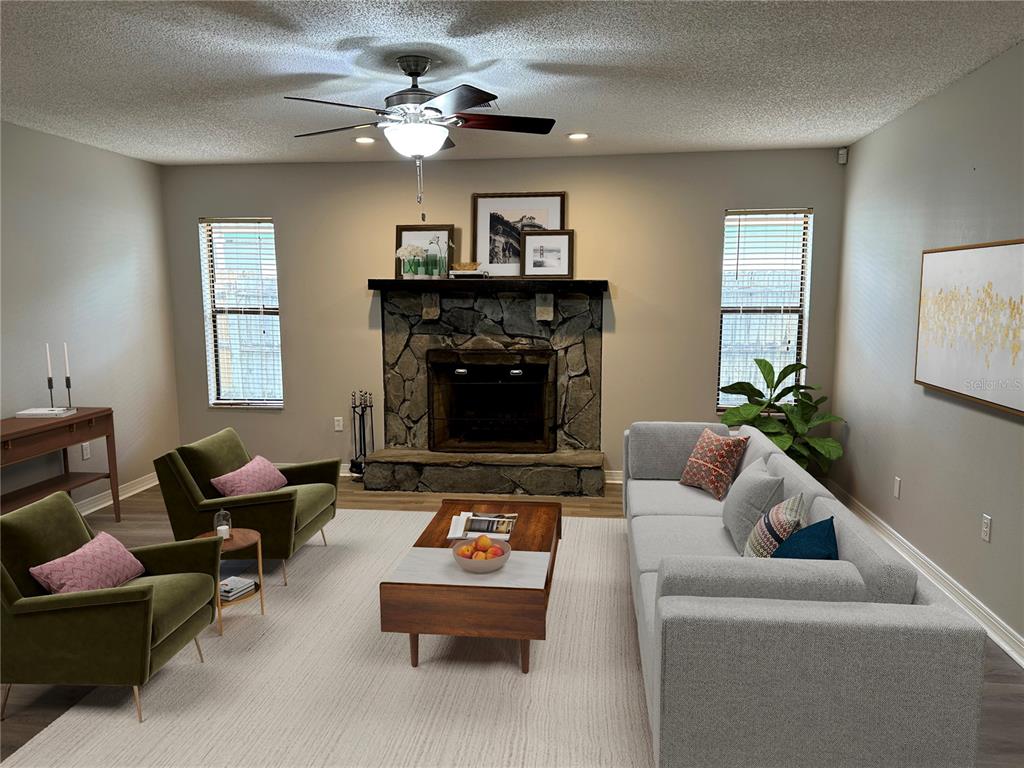 A living room features a stone fireplace, gray sofa, two green armchairs, and wood flooring — 2013 KAMENSKY ROAD, CLEARWATER, FL