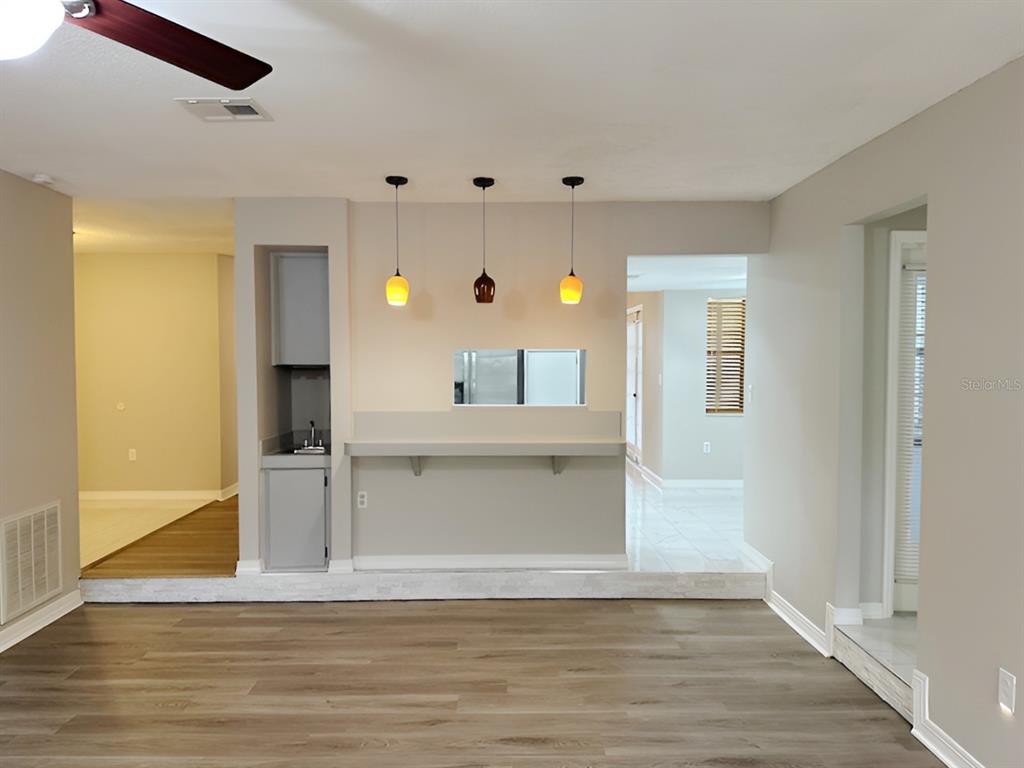 A living area features light wood-look flooring, a breakfast bar, and a small wet bar — 2013 KAMENSKY ROAD, CLEARWATER, FL