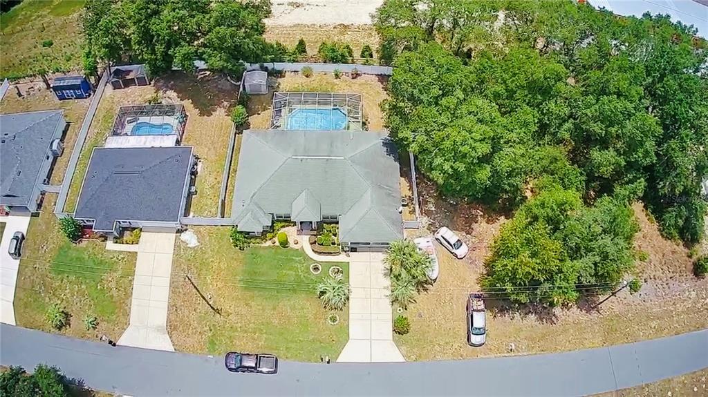An aerial view shows a house with a pool, driveway, and surrounding trees — 13620 SW 48TH COURT, OCALA, FL