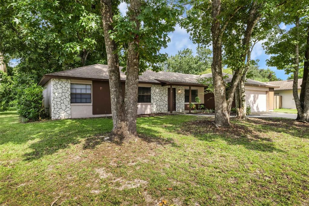 A single-story house with stone veneer accents, brown trim, and a two-car garage — 113 LIDO ROAD, WINTER SPRINGS, FL