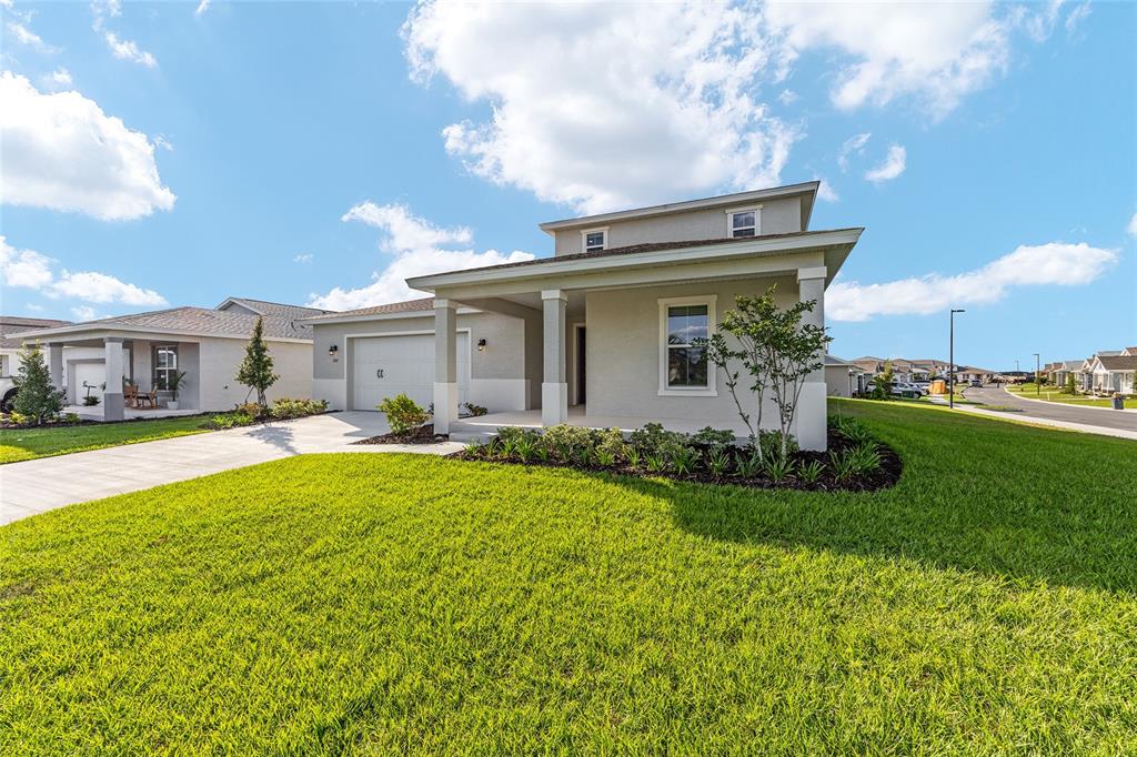 A single-story suburban house with a covered front porch, garage, and landscaped lawn — 7157 SW 57TH PLACE, OCALA, FL