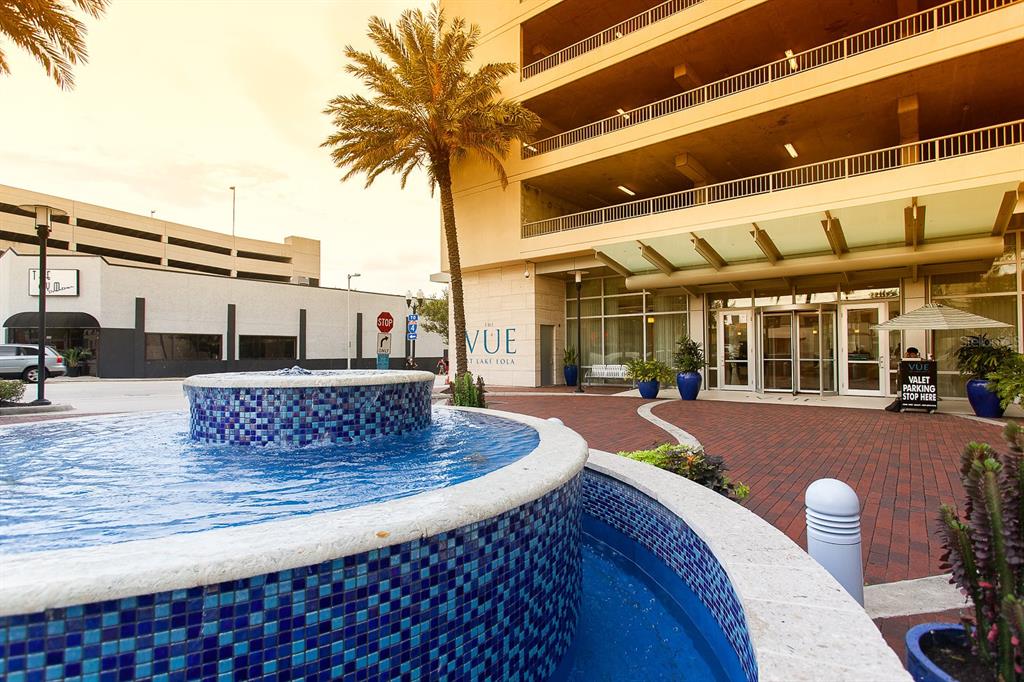 A blue tiled fountain sits in front of a modern building entrance with valet parking — 150 E ROBINSON STREET UNIT 1415, ORLANDO, FL