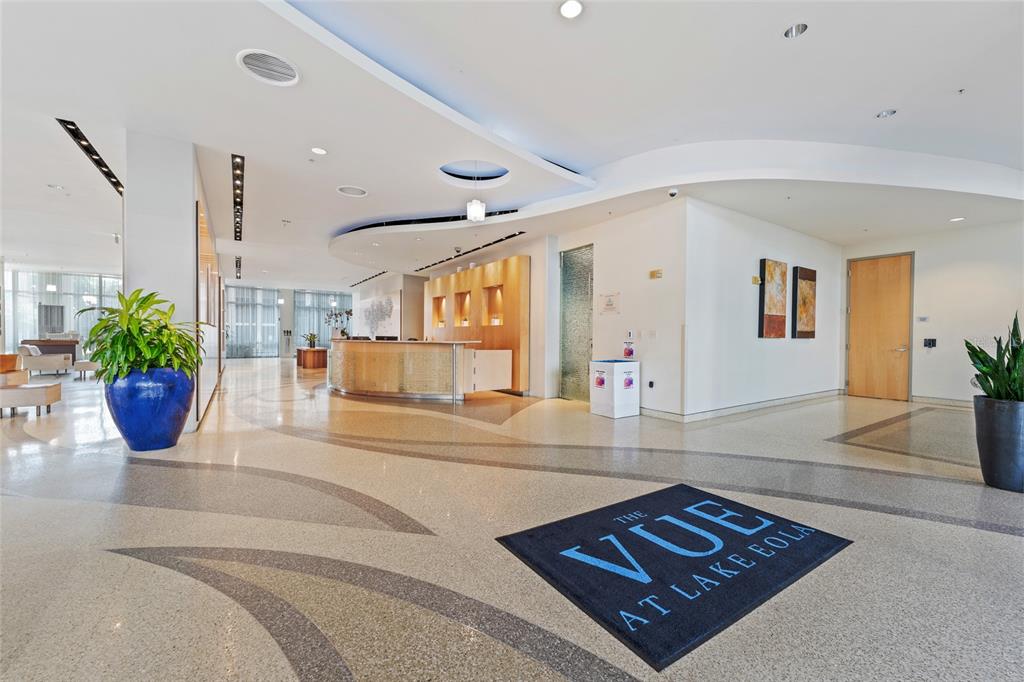 A modern lobby features a reception desk, patterned flooring, and a branded entrance mat — 150 E ROBINSON STREET UNIT 1415, ORLANDO, FL