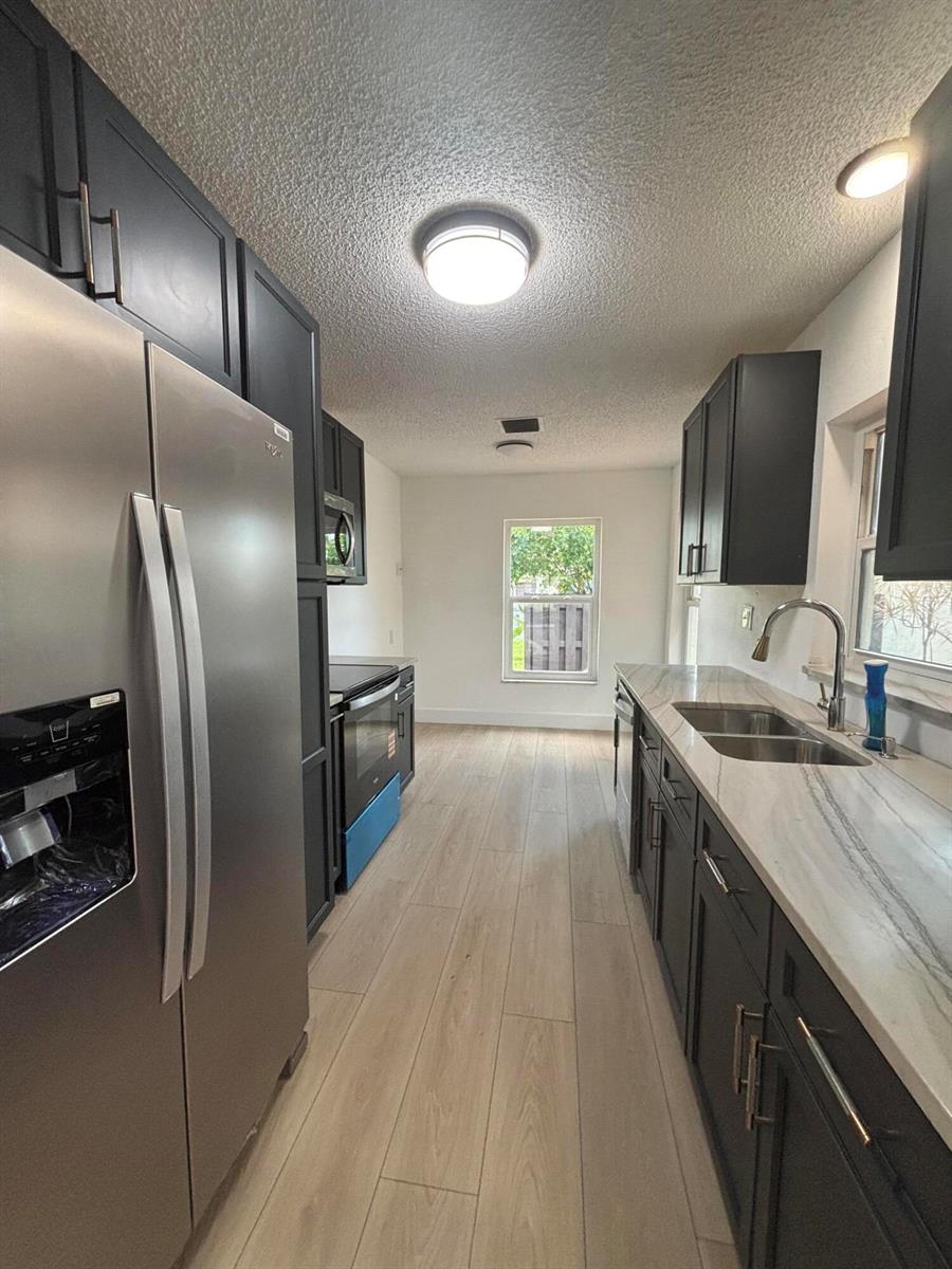 A screened-in porch with a metal frame attached to the side of a stucco house — 5430 Mirror Lakes Boulevard, Boynton Beach FL 33472, BOYNTON BEACH, FL