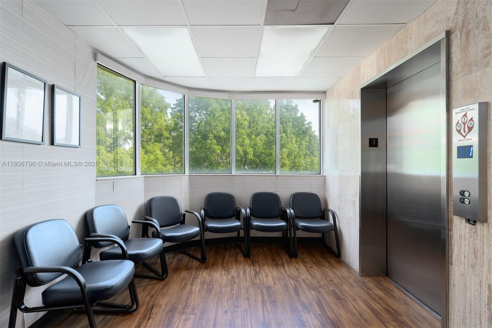 A waiting area features six black chairs, wood-look flooring, large windows, and an elevator — 1378 Coral Way # 3, Miami FL 33145, MIAMI, FL