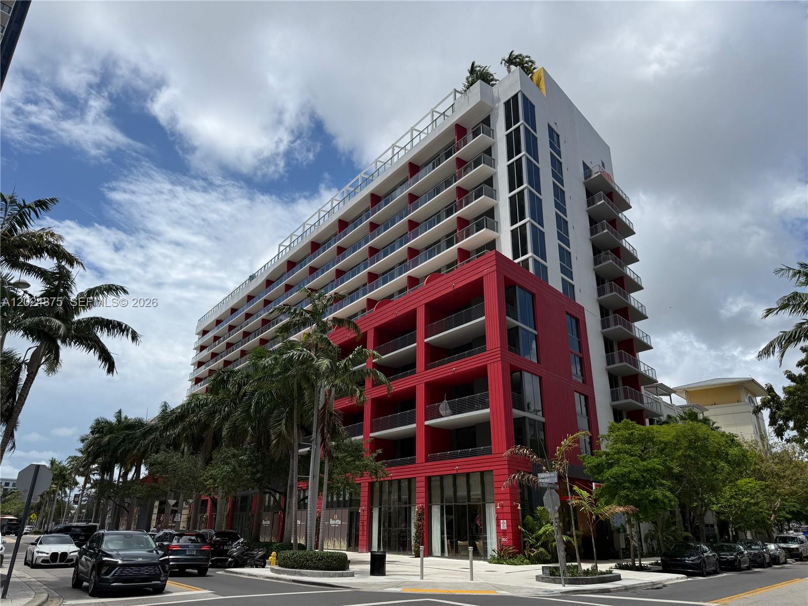 A modern multi-story building features a red-accented lower section and white upper balconies — 90 NE 32 # 1016, Miami FL 33137, MIAMI, FL