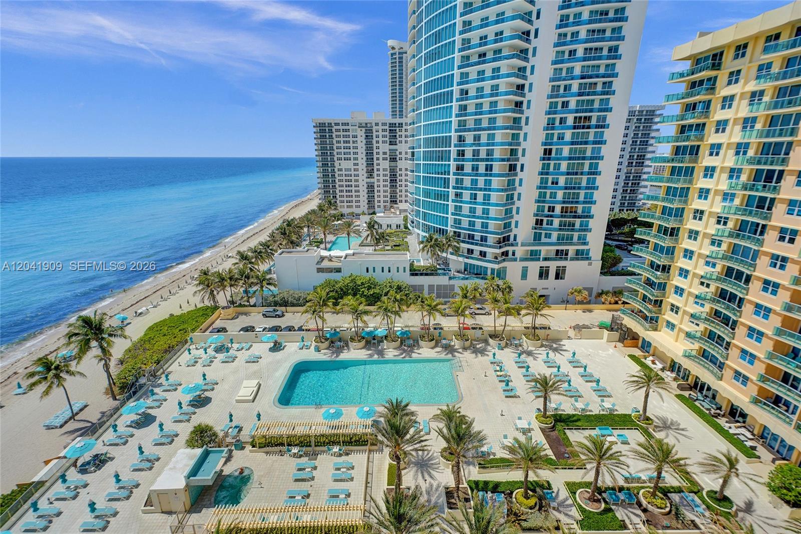 An elevated view of a beachside swimming pool deck surrounded by high-rise residential buildings — 2501 S Ocean Dr, Hollywood FL 33019, HOLLYWOOD, FL