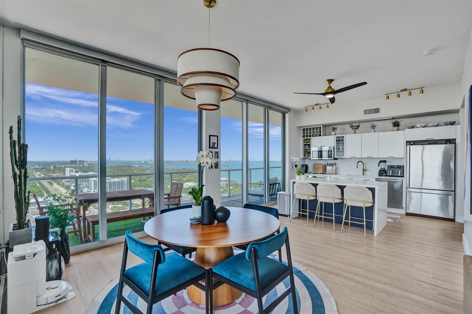 A modern dining area and kitchen with floor-to-ceiling windows overlooking a coastal city view — 3470 E Coast Avenue # H2704, Miami FL 33137, MIAMI, FL