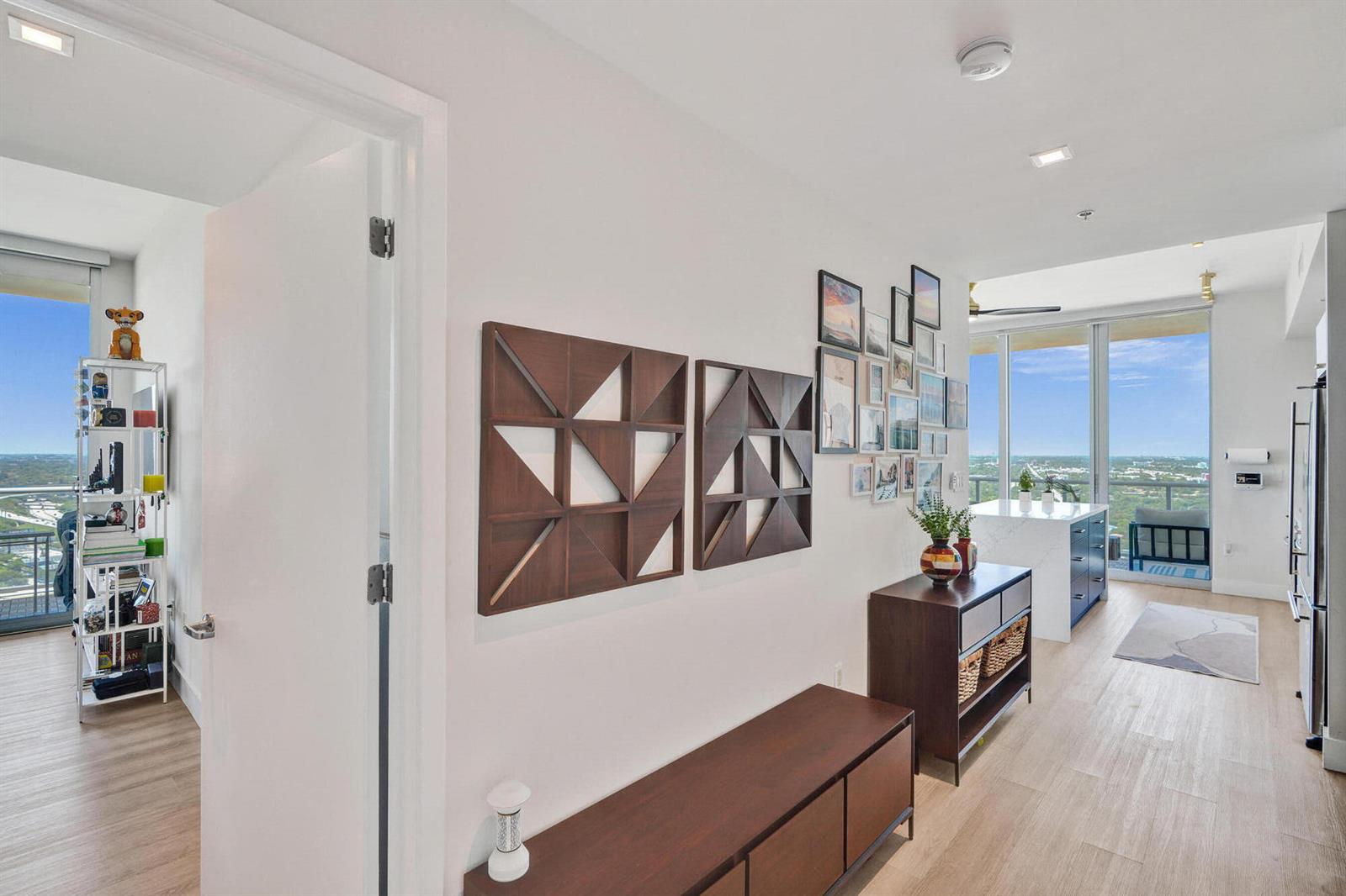 A hallway leads to a bright living area with a kitchen, balcony, and city views — 3470 E Coast Avenue # H2704, Miami FL 33137, MIAMI, FL