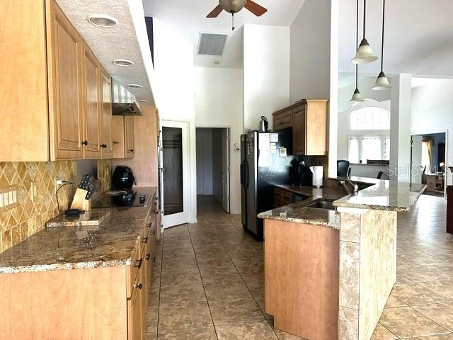 A kitchen features light wood cabinets, granite countertops, tile flooring, and a breakfast bar — 4 PINEHURST PLACE, ROTONDA WEST, FL