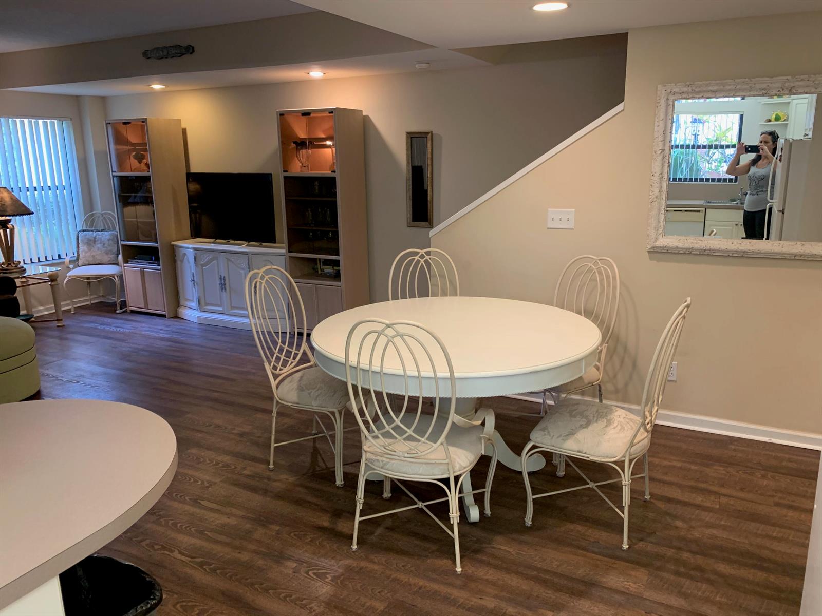 A dining area with a round white table and metal chairs sits on wood flooring — 49 Uno Lago Drive, Juno Beach FL 33408, JUNO BEACH, FL