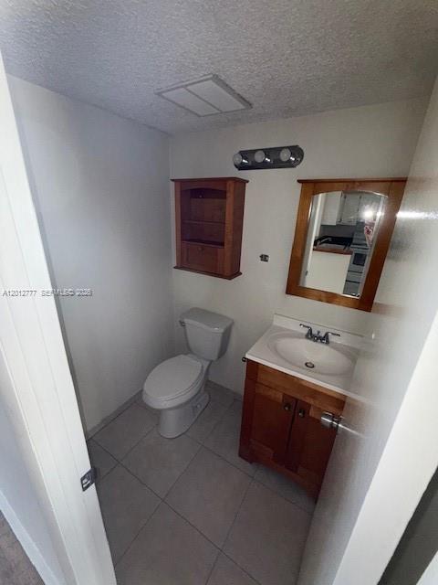 A small bathroom features a toilet, a wooden vanity with a sink, and a wall cabinet — 406 NW 68th Ave # 411, Plantation FL 33317, PLANTATION, FL