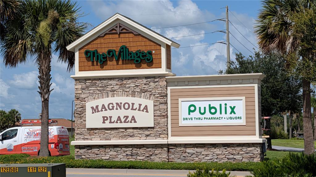 A stone and wood monument sign for Magnolia Plaza in The Villages stands outdoors — 5211 WARM SPRINGS AVENUE, WILDWOOD, FL