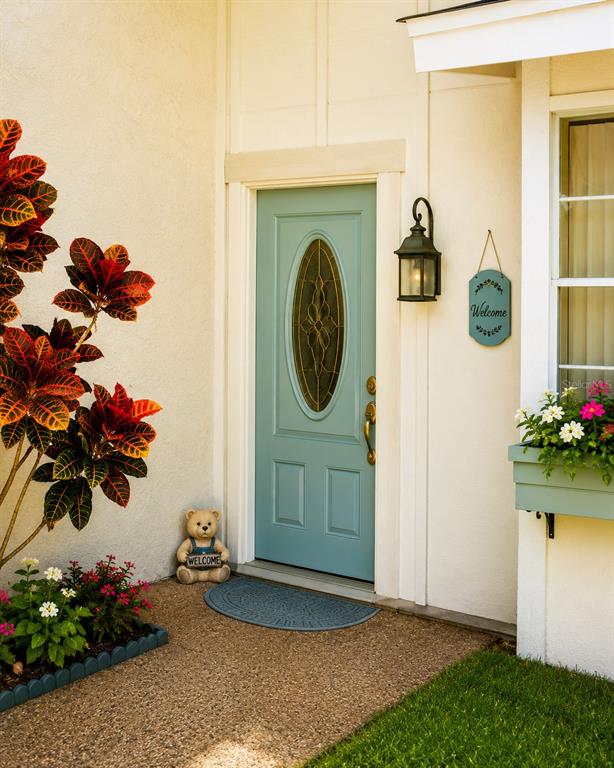 A light blue front door with an oval glass insert sits beside a potted plant — 4238 PINEFIELD AVENUE, HOLIDAY, FL