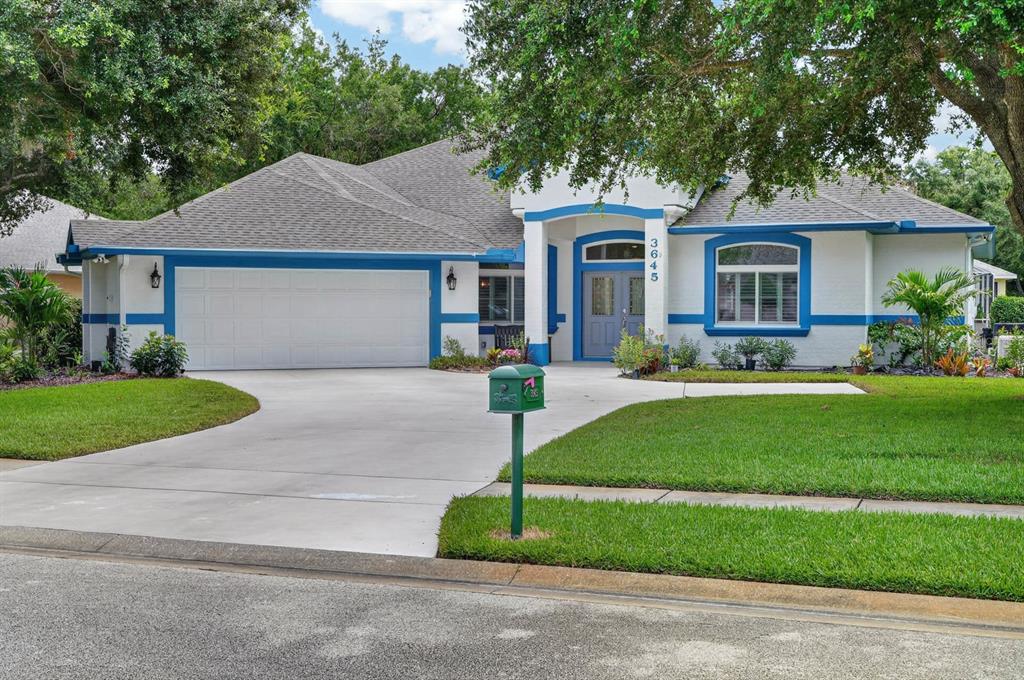 A single-story house with a white stucco exterior, blue trim, and a two-car garage — 3645 CHRISTA COURT, ORMOND BEACH, FL