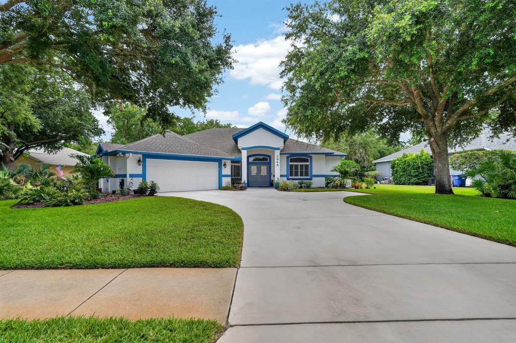 A single-story house with a white stucco exterior, blue trim, and a concrete driveway — 3645 CHRISTA COURT, ORMOND BEACH, FL