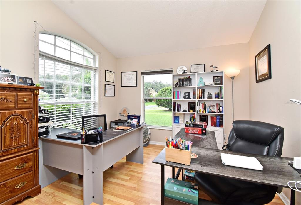A home office with two desks, a bookshelf, wood-look flooring, and two windows — 2634 GOLD DUST CIRCLE, KISSIMMEE, FL
