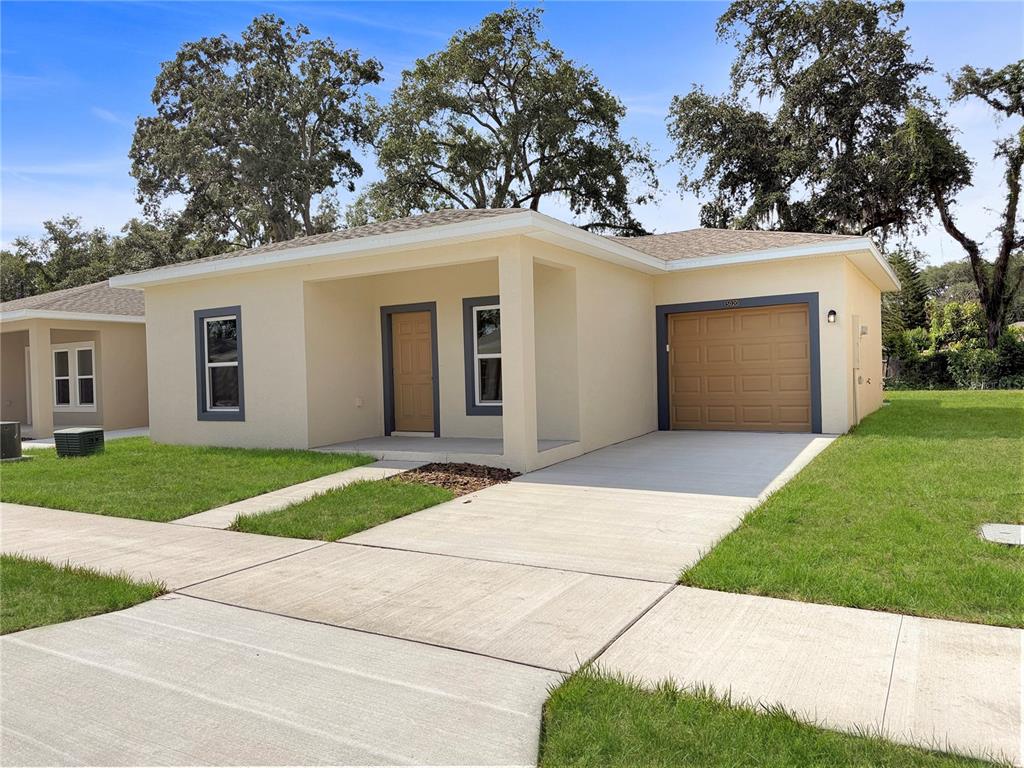 A single-story house with a tan exterior, a front porch, and an attached garage — 5020 FINDERS COURT, TAMPA, FL