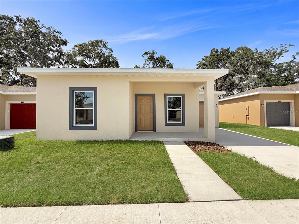 A single-story house with a tan exterior, a covered entryway, and a concrete walkway — 5020 FINDERS COURT, TAMPA, FL