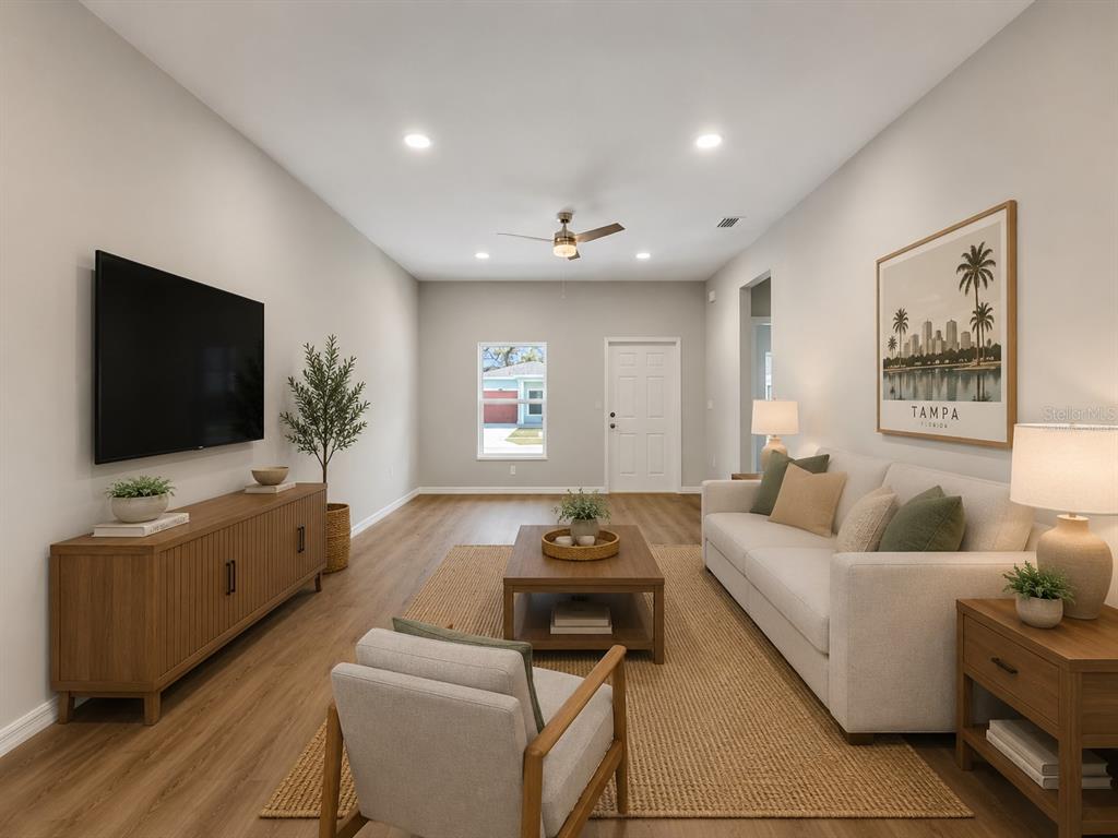 A living room features a television, a sofa, an armchair, and a wooden media console — 5020 FINDERS COURT, TAMPA, FL
