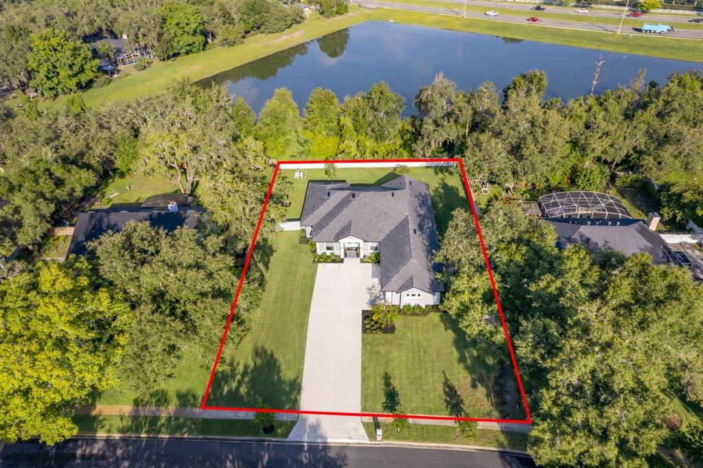 A spacious open-concept living room features a large sectional sofa, tile flooring, and a kitchen — 2766 SHANNIN DRIVE, ST CLOUD, FL