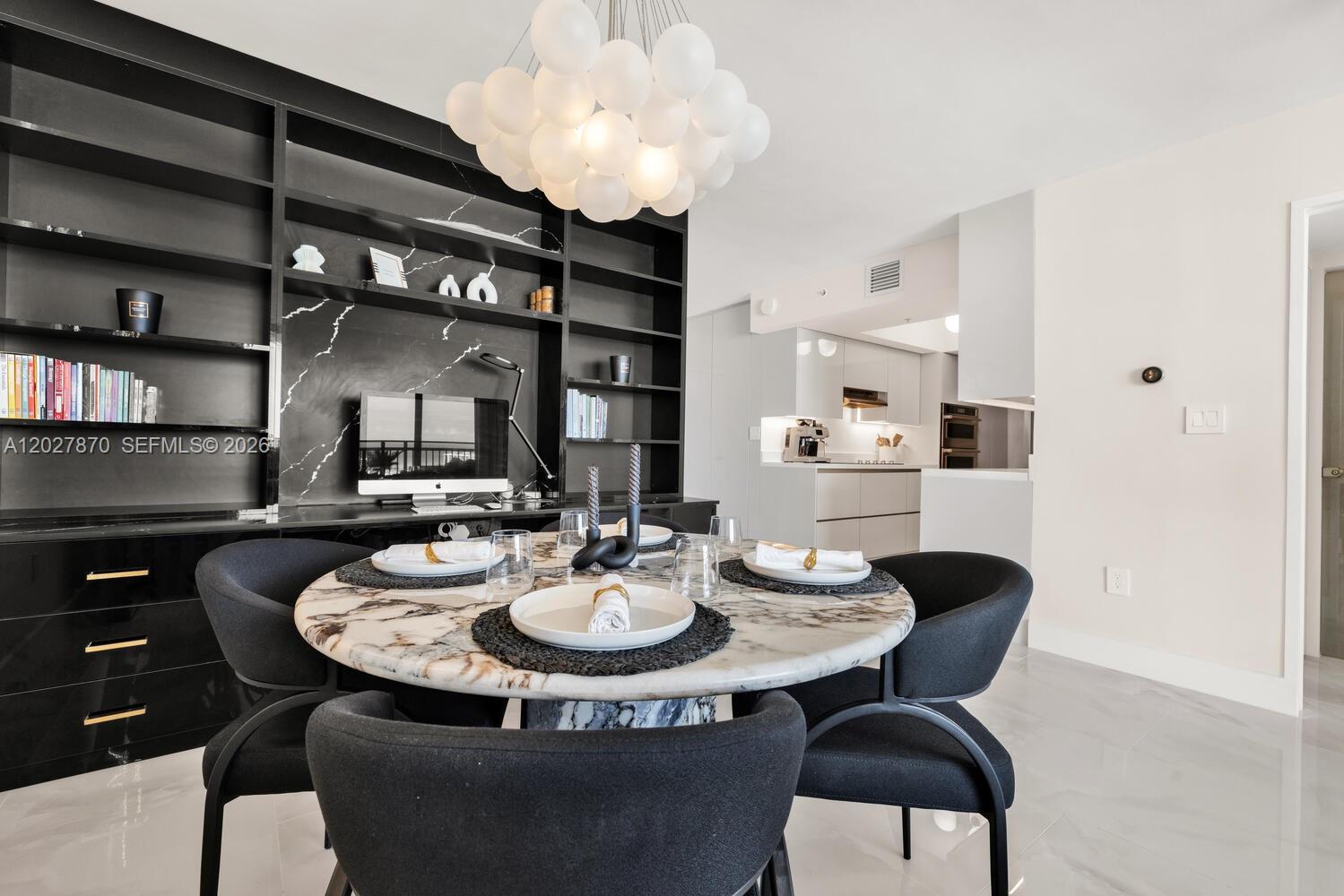 A dining area features a marble table, black chairs, and a built-in shelving unit — 90 Alton Rd # 2207, Miami Beach FL 33139, MIAMI BEACH, FL