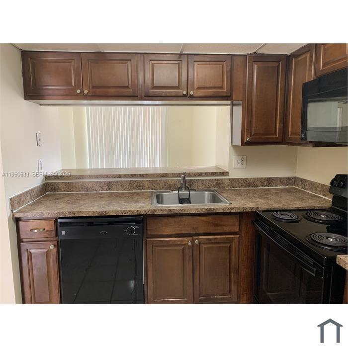 A kitchen features brown wooden cabinets, a laminate countertop, a sink, and black appliances — 19791 SW 114th Ave # 331, Miami FL 33157, MIAMI, FL