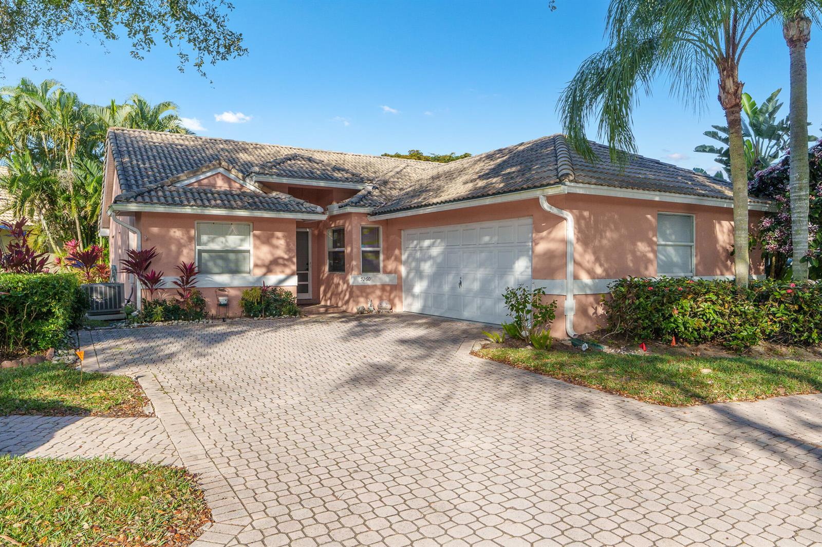 A single-story peach-colored house with a tiled roof and a paved driveway — 5260 Grande Palm Circle, Delray Beach FL 33484, DELRAY BEACH, FL