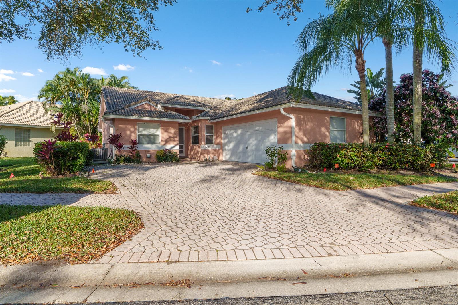 A single-story peach-colored house with a tiled roof and a paved driveway — 5260 Grande Palm Circle, Delray Beach FL 33484, DELRAY BEACH, FL