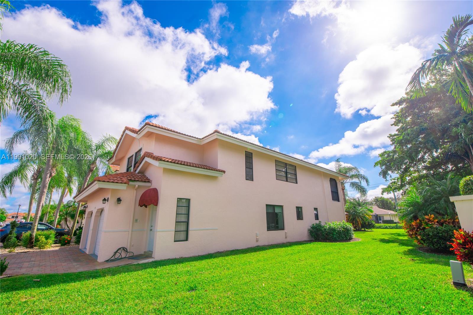 A two-story, light-pink stucco house with a tile roof sits on a grassy lawn — 8694 Via Reale # 3, Boca Raton FL 33496, BOCA RATON, FL