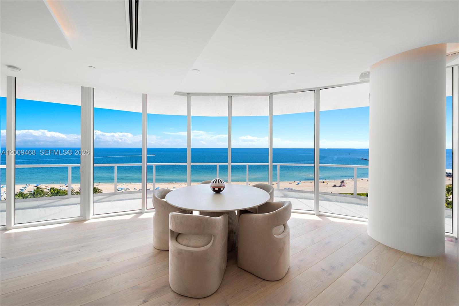 A dining area features a round table, four chairs, and floor-to-ceiling windows overlooking the ocean — 100 S Pointe Dr # 1206, Miami Beach FL 33139, MIAMI BEACH, FL