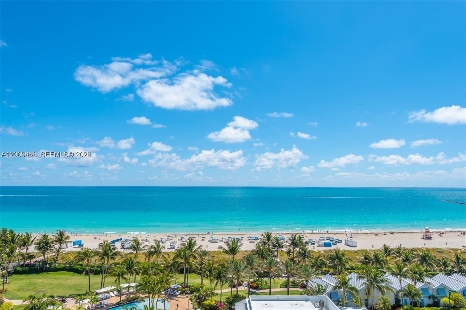 An elevated view of a sandy beach with palm trees and the ocean beyond — 100 S Pointe Dr # 1206, Miami Beach FL 33139, MIAMI BEACH, FL
