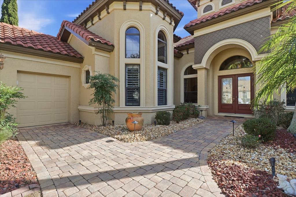 A paved walkway leads to the front entrance and garage of a Mediterranean-style home — 1416 N RIDGE MEADOW PATH, HERNANDO, FL