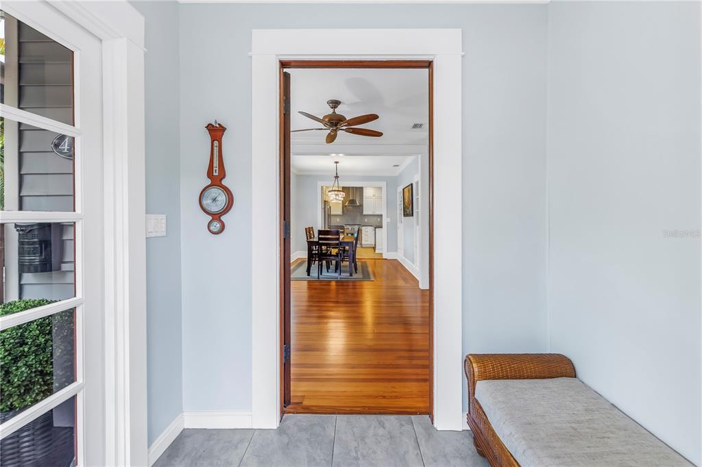 A living room with hardwood floors leads into a dining area and kitchen — 436 12TH AVENUE NE, ST PETERSBURG, FL