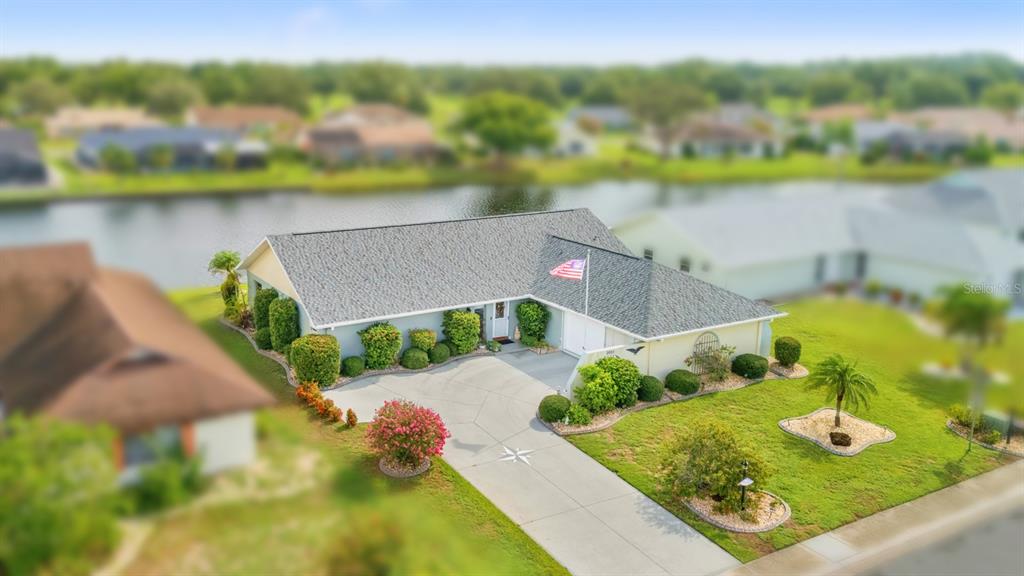 An aerial view of a single-story house with a gray roof and a concrete driveway — 2023 EL RANCHO DRIVE, SUN CITY CENTER, FL