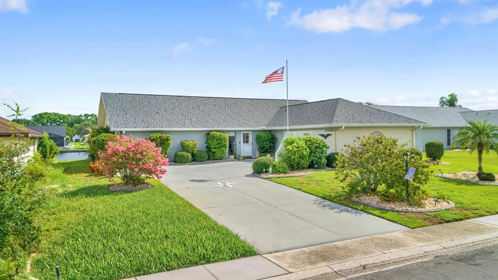 A single-story house with a gray roof, a concrete driveway, and a front yard — 2023 EL RANCHO DRIVE, SUN CITY CENTER, FL