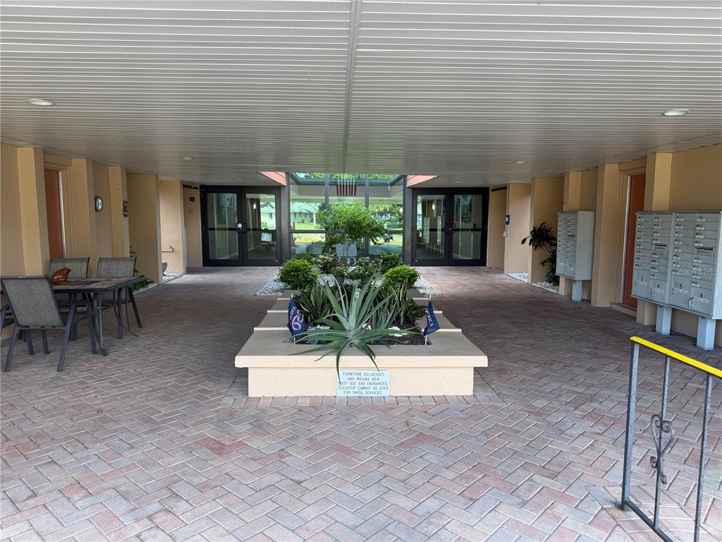A covered outdoor entryway features brick pavers, a central planter, and mailboxes — 2290 AARON STREET UNIT 101, PORT CHARLOTTE, FL