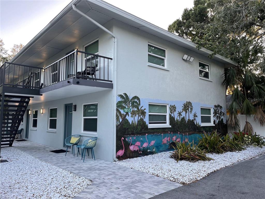 A two-story apartment building features a flamingo mural on the exterior wall and white gravel — 1912 MORRILL UNIT Lime, SARASOTA, FL