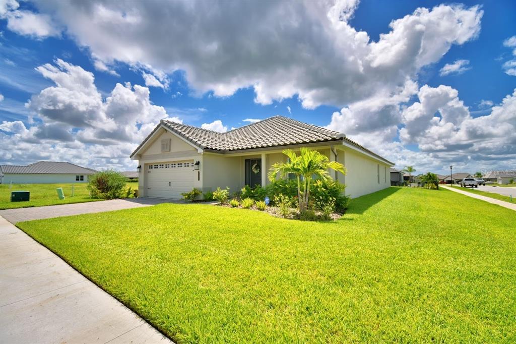 A single-story house with a beige exterior, a tiled roof, and a green lawn — 4669 GRANDVIEW GLEN DRIVE, AUBURNDALE, FL