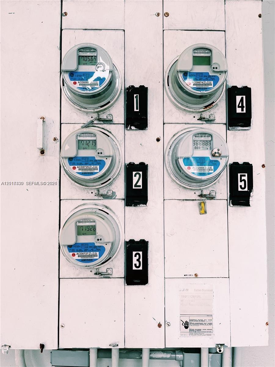 A wall-mounted electrical panel features five digital utility meters and corresponding numbered disconnect switches — 7630 Byron Ave, Miami Beach FL 33141, MIAMI BEACH, FL