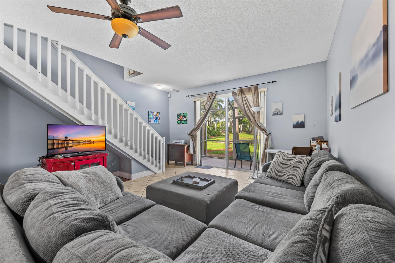 A living room features a grey sectional sofa, a staircase, and sliding glass doors — 2185 Salerno Circle, Weston FL 33327, WESTON, FL