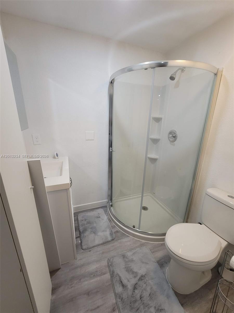 A small bathroom features a corner glass shower, a white vanity, and a toilet — 4201 SW 32nd Dr # 1, West Park FL 33023, WEST PARK, FL