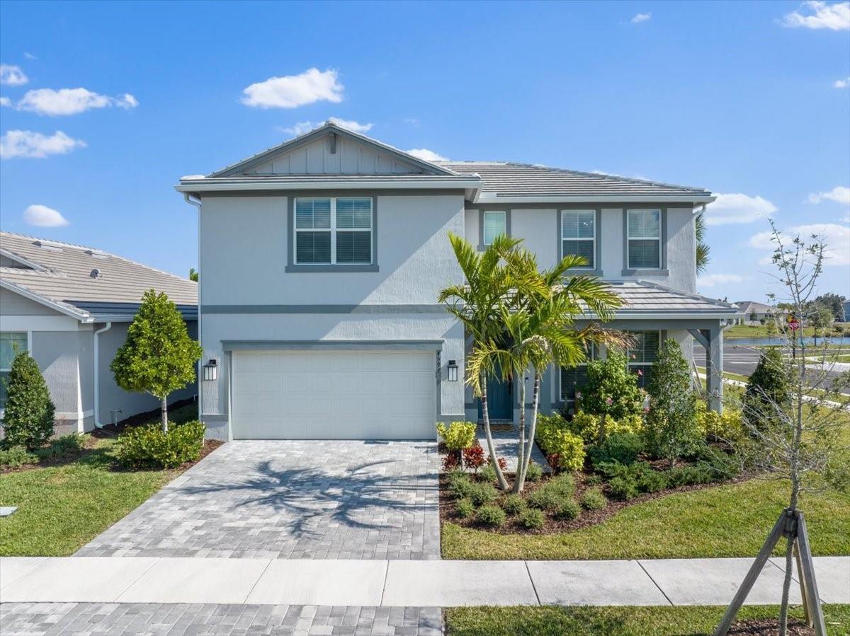 An open-concept living room features a grey sectional sofa, two leather chairs, and a kitchen — 4597 Nautilus Circle, Vero Beach FL 32967, VERO BEACH, FL