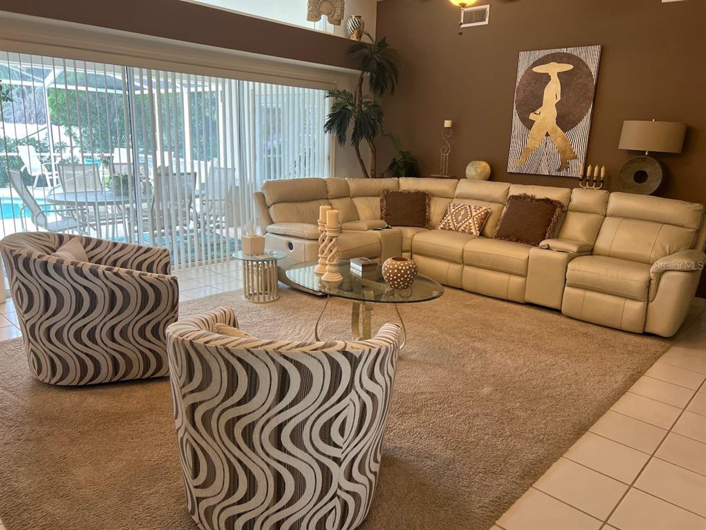 The exterior of a house features a covered entryway with a white door and landscaping — 120 WOODCREST LANE, MULBERRY, FL