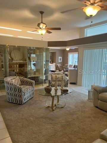 An entryway features a white door, a crystal chandelier, a console table, and tile flooring — 120 WOODCREST LANE, MULBERRY, FL